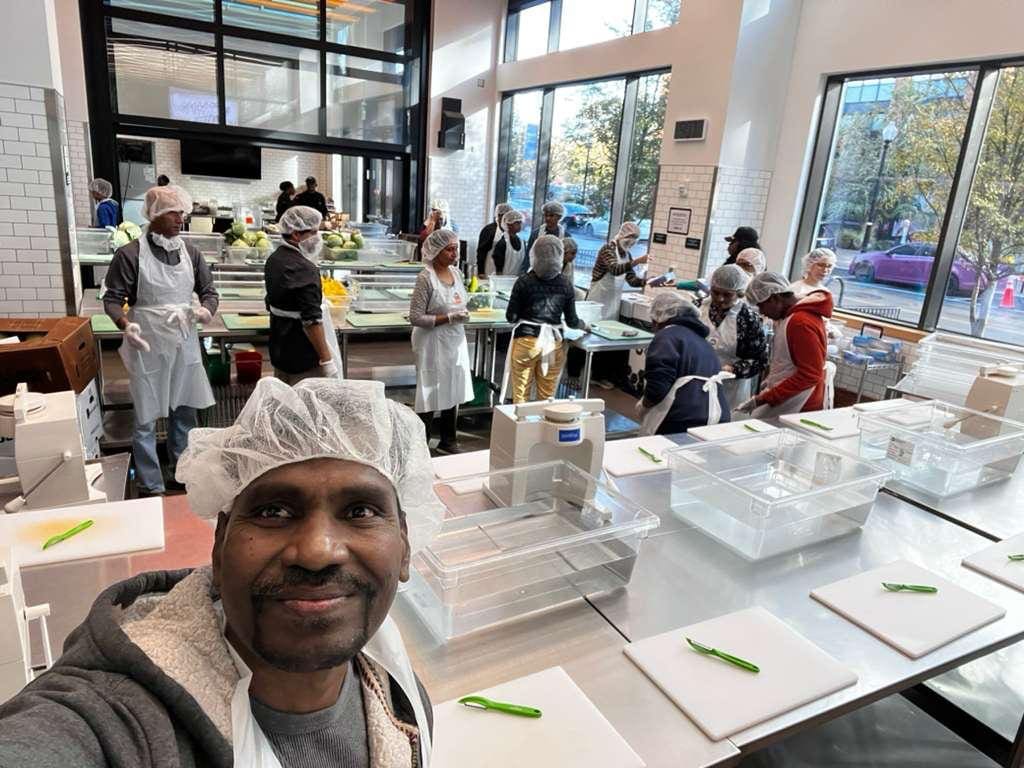 Volunteers preparing food in bright commercial kitchen