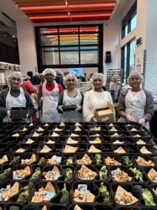 Volunteers packing meal trays at cafeteria